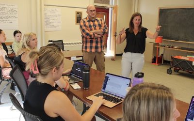 Professors Theoharis and Myers teaching a group of students.